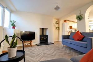 a living room with a blue couch and a fire place at 4 bed home 3 mins from harbour + sandy beach in Kent