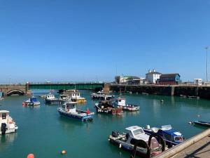 a group of boats are docked in a harbor at 4 bed home 3 mins from harbour + sandy beach in Kent