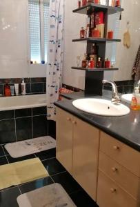 a bathroom with a sink and a black tiled floor at Welcome in Pontivy