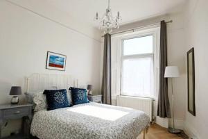 Un dormitorio con una cama con almohadas azules y una ventana en 4 bed home 3 mins from harbour + sandy beach en Kent