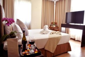 ein Hotelzimmer mit einem Bett und einem TV in der Unterkunft Aura One Hotel in Baguio City
