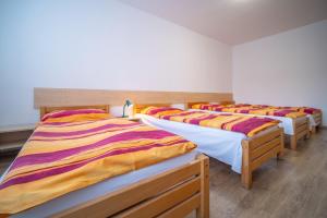 a row of four beds in a room at Hotel U Nádraží in České Budějovice