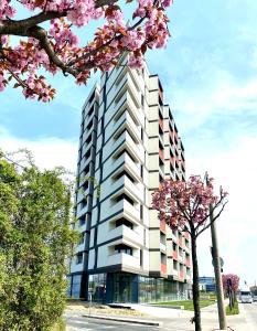 ティミショアラにあるGolden Penthouse Rebreanu Residenceの目の前に花木がある建物