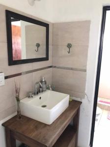 a bathroom with a white sink and a mirror at Casa en Potrero de Garay con pileta in Potrero de Garay