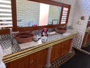 een badkamerbar met een wastafel en een spiegel bij ETNICO LOCAL HOUSE in Chiconcuac