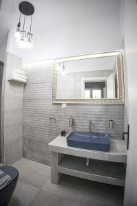 a bathroom with a blue sink and a mirror at Countryside luxury studios in Káto Lekhónia