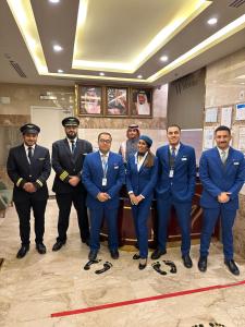 um grupo de homens em fatos posando para uma foto em Assilah Hotel em Al Madinah