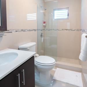 uma casa de banho com um WC e uma cabina de duche em vidro. em Aquaville Dorado Moderna Villa 5 em Dorado