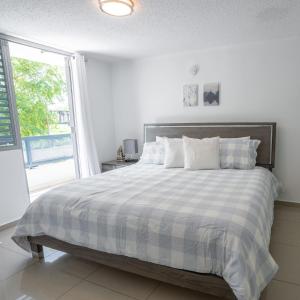 a bedroom with a bed with a checkered blanket at Aquaville Dorado Moderna Villa 5 in Dorado