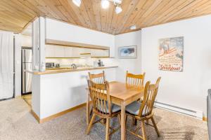 a kitchen and dining room with a wooden table and chairs at A Scent of Pine in Steamboat Springs