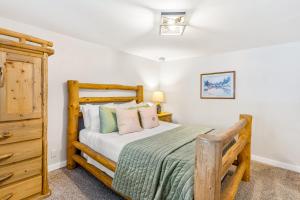 um quarto com uma cama de madeira e uma cómoda em A Scent of Pine em Steamboat Springs