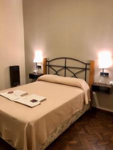 a bedroom with a bed with two lamps on it at Hotel Bonino in Villa Mercedes