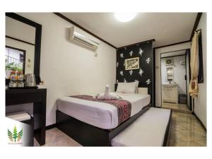 a bedroom with a large bed and a piano at Royal Caravan Trawas Hotel in Trawas