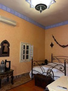 a bedroom with two beds and a chandelier at Ksar Jenna in Nkob