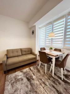 sala de estar con sofá, mesa y sillas en Dream apartment Gotse Delchev, en Gotse Delchev