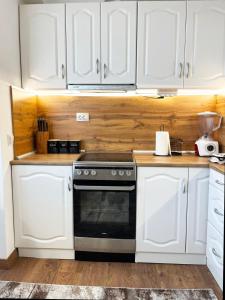 a kitchen with white cabinets and a black oven at Dream apartment Gotse Delchev in Gotse Delchev