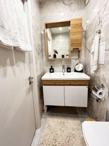 Baño blanco con lavabo y espejo en Dream apartment Gotse Delchev, en Gotse Delchev