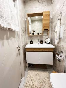 a white bathroom with a sink and a mirror at Dream apartment Gotse Delchev in Gotse Delchev