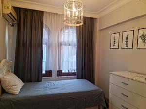 - une chambre avec un lit et une fenêtre ornée d'un lustre dans l'établissement luxury apartment with fireplace, à Istanbul