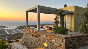 a stone wall outside of a house with a patio at Tetrapolis Keos in Milopótamos