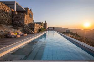 a infinity pool with the sunset in the background at Tetrapolis Keos in Milopótamos