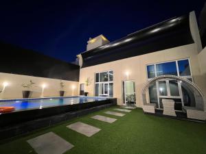 a house with a swimming pool at night at Arayik Resort in Taif