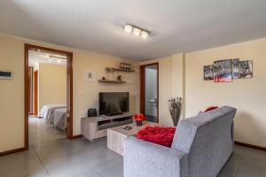 a living room with a couch and a television at Gran Horizonte House with private pool by HR Madeira in Ribeira Brava