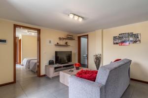 een woonkamer met een bank en een televisie bij Gran Horizonte House by Holiday Rental Madeira in Ribeira Brava
