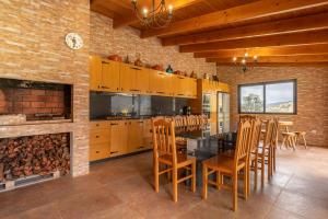 een keuken met een tafel en stoelen en een open haard bij Gran Horizonte House by Holiday Rental Madeira in Ribeira Brava