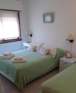1 dormitorio con 1 cama con 2 toallas en Hotel Barracuda en Villa Gesell