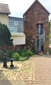 a brick house with a bird bath in front of it at Modernisiertes Gästezimmer im Ortskern in Wehrheim