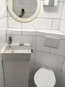 y baño con aseo, lavabo y espejo. en Modernisiertes Gästezimmer im Ortskern, en Wehrheim