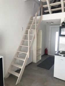 a white staircase in a room with a wall at Modernisiertes Gästezimmer im Ortskern in Wehrheim