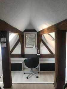 um quarto no sótão com uma secretária e uma cadeira em Modernisiertes Gästezimmer im Ortskern em Wehrheim