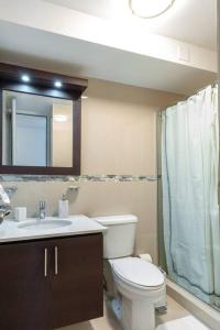 La salle de bains est pourvue de toilettes, d'un lavabo et d'un miroir. dans l'établissement Aquaville Dorado Moderna Villa 1, à Dorado