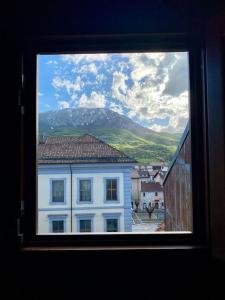 een raam met uitzicht op een wit gebouw bij Casa di montagna nel borgo di Rocca di Mezzo in Rocca di Mezzo