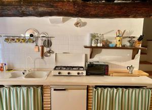 una cucina con lavandino e piano cottura forno superiore di Casa di montagna nel borgo di Rocca di Mezzo a Rocca di Mezzo