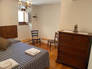 sypialnia z łóżkiem, komodą i krzesłami w obiekcie Casa di montagna nel borgo di Rocca di Mezzo w mieście Rocca di Mezzo