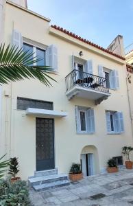 een wit gebouw met een balkon en een deur bij Athens Plaka Family Suites in Athene