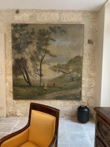 N15 - Les Confidences - Chambres d'hôtes في أفينيون: لوحة معلقة على جدار بجوار كرسي