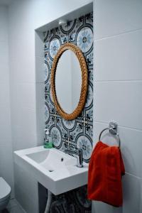 La salle de bains est pourvue d'un lavabo blanc et d'un miroir. dans l'établissement Seaview 2-bedroom Apartment in Xlendi, à Xlendi