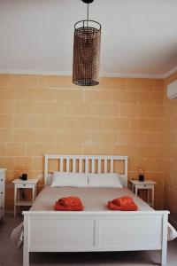 1 dormitorio con 1 cama blanca y 2 almohadas rojas. en Seaview 2-bedroom Apartment in Xlendi, en Xlendi