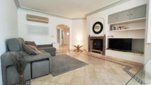 a living room with a couch and a fireplace at Sao Rafel Beach house in Albufeira