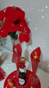 zwei rote Vasen mit roten Blumen auf dem Tisch in der Unterkunft B&B Petra Hercules in Torre Annunziata