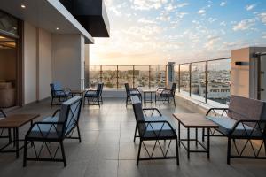 un restaurante con mesas y sillas en un balcón en Gladiolus Hotel, en Yeda
