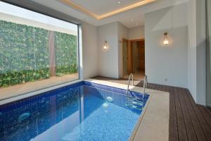 a swimming pool in a house with a large window at Gladiolus Hotel in Jeddah