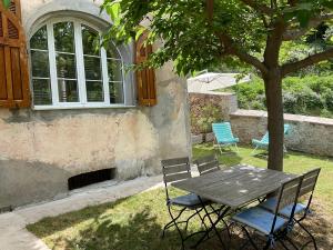 une table de pique-nique et des chaises assises sous un arbre dans l'établissement Casa Defranchi, à Sant Andrea di Bozio