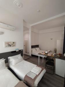 um quarto com 2 camas, uma secretária e uma mesa em Domus Nikolai em Bari