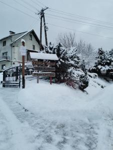 a sign in the snow in front of a house at agroturystyka Pensjonat PAULA in Muszyna