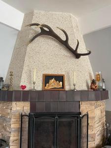 a fireplace with antlers on top of it at agroturystyka Pensjonat PAULA in Muszyna